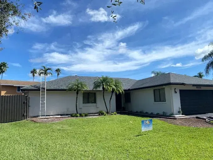 Single-story home with a new gray shingle roof under a blue sky