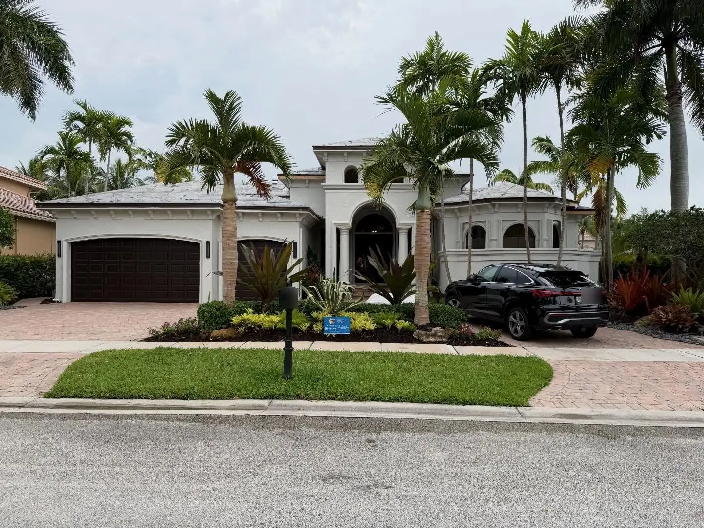 White Mediterranean-style home in Hawks Landing, Plantation, framed by palms, its roof sealed in white underlayment and ready for tile