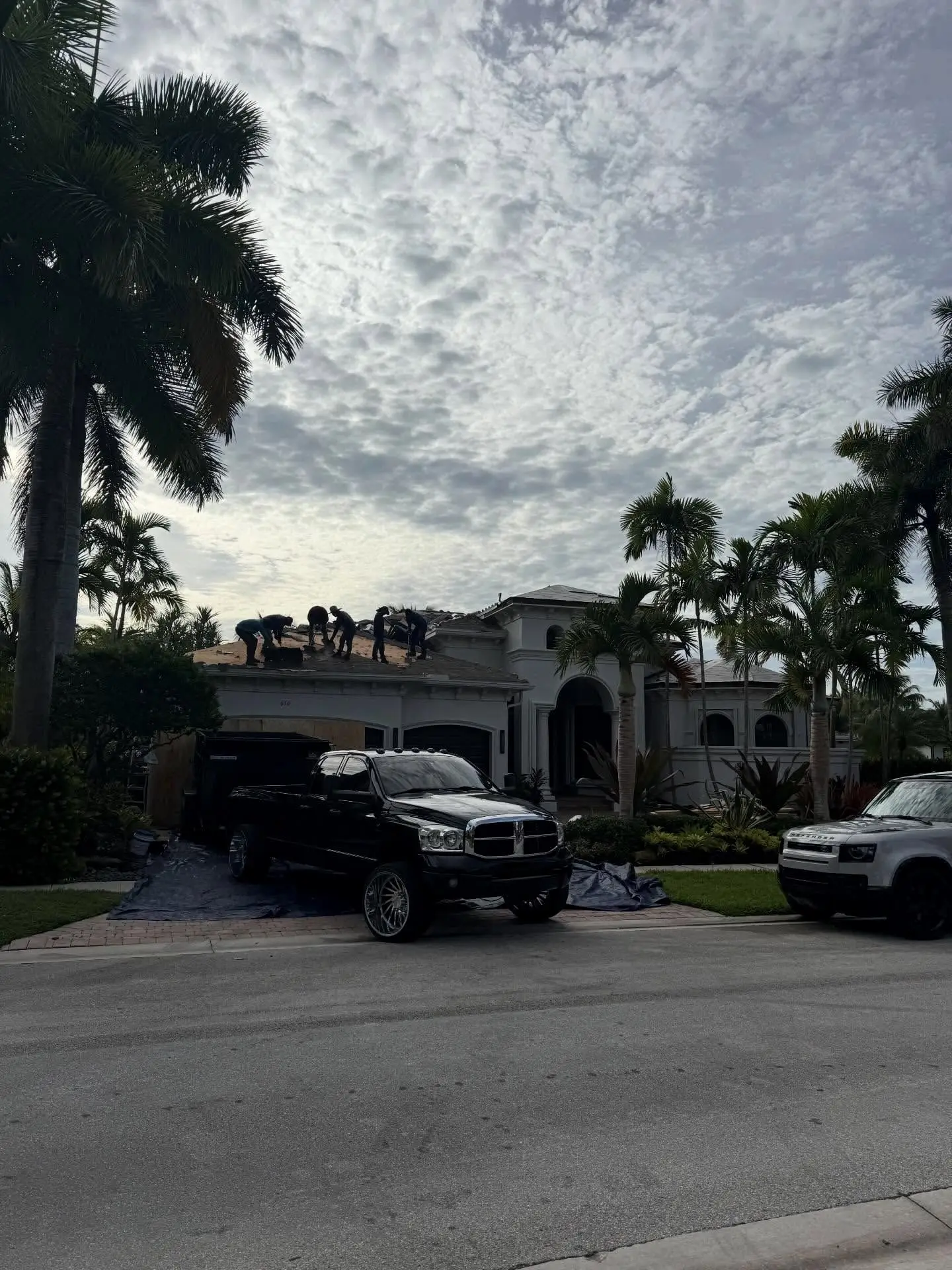 Roofing crew at work on the first morning of a re-roof at a large home in Hawks Landing, Plantation