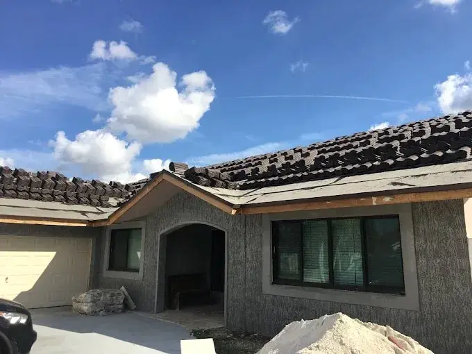 New concrete tiles going onto a ranch-style home, with tile stacked along the ridge