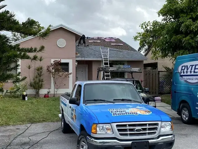 Glades Edge Roofing pickup parked at a pink home during a tile tear-off