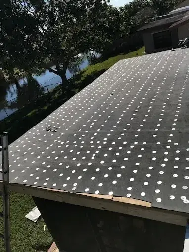 Close view of new underlayment fastened with cap nails on a roof deck